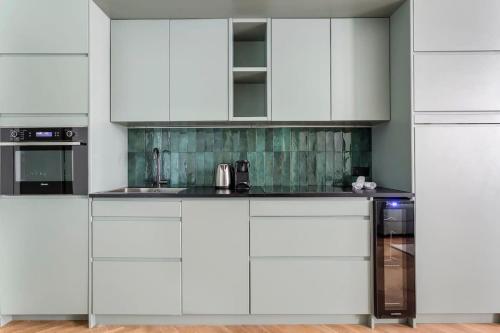 een witte keuken met witte kasten en een spoelbak bij Suite St Antoine 4 travelers in Lyon