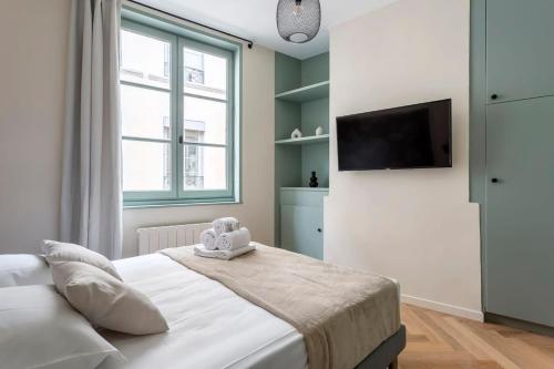 een slaapkamer met een bed en een flatscreen-tv bij Suite St Antoine 4 travelers in Lyon