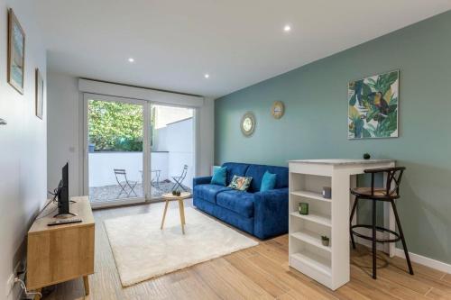 un salon avec un canapé bleu et une télévision dans l'établissement Hamac Suites - Le Valdo - 2 pers, à Lyon