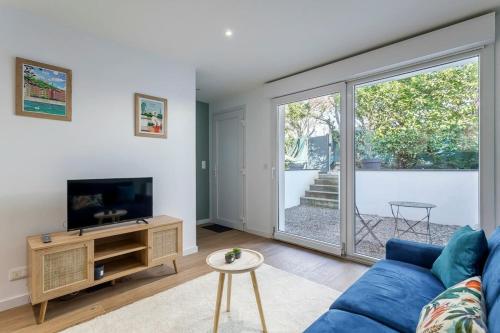 un salon avec un canapé bleu et une télévision dans l'établissement Hamac Suites - Le Valdo - 2 pers, à Lyon