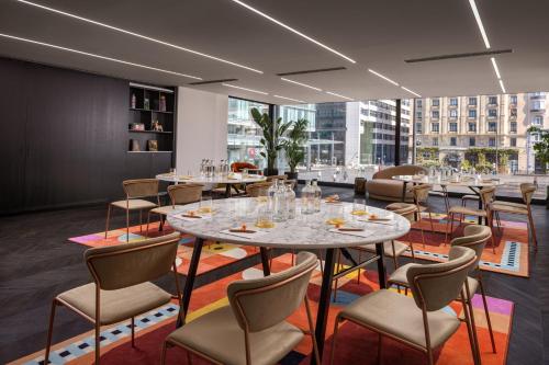 a restaurant with tables and chairs and a large window at Cardo Brussels, Autograph Collection in Brussels
