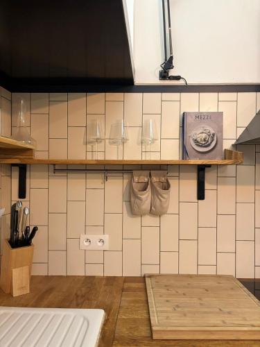 - une cuisine avec des murs carrelés blancs et une étagère dans l'établissement Le Yellow Submarine - Loft - Hyper centre, à Toulouse