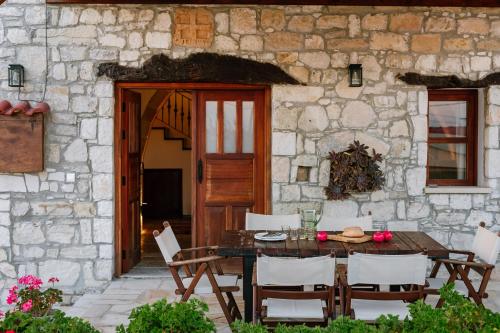 a table and chairs in front of a stone building at Iliada's Traditional Stone House in Paphos City