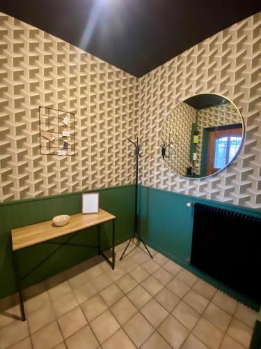 a room with a table and a mirror at Maison paisible, parking privé proche Micropolis in Besançon