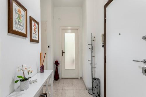 Baño blanco con lavabo y puerta en Casa Cristina bright and spacious Rome Apartment, en Roma
