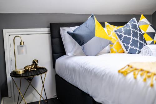 a bedroom with a bed with colorful pillows at Quiet Top-Floor Retreat -Modern Studio for 2 - Islington in London