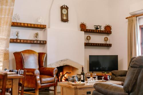 a living room with a fireplace and a television at Iliada's Traditional Stone House in Paphos City