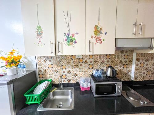 a kitchen with a sink and a microwave at Sea Residences Sailor in Manila