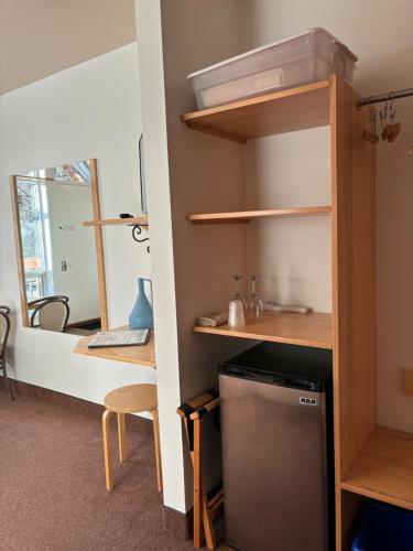 a room with a kitchen with a desk and shelves at Auberge du Jardin in Petit-Saguenay
