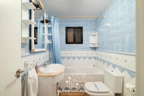 a blue tiled bathroom with a toilet and a sink at LaCalma Village with private pool By AlohaMálaga in Málaga