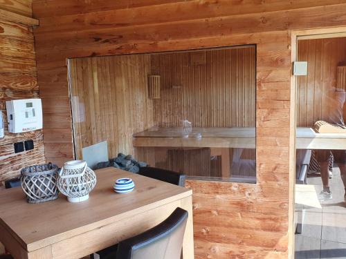 a room with a wooden wall with a wooden table at Holiday cottage with sauna in Zeeland in Stavenisse