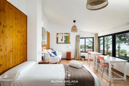 a bedroom with a bed and a table and a dining room at LaCalma Village with private pool By AlohaMálaga in Málaga