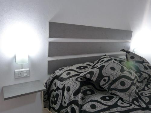 Un dormitorio con una cama con cabecero y dos lámparas. en Santa Isabel Departamentos, en Valle María