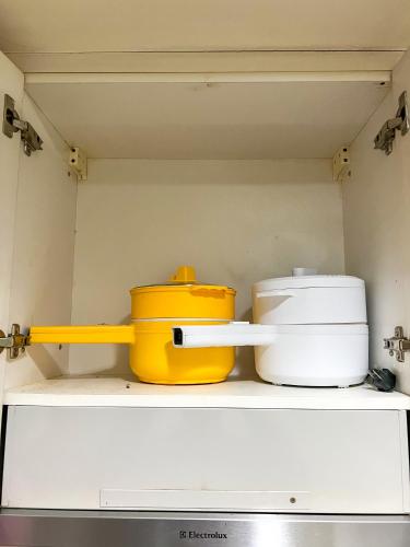 a shelf with some pots and pans on it at Sea Residences Sailor in Manila