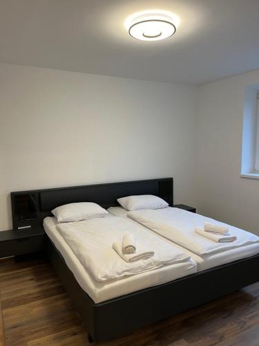 un letto con lenzuola e cuscini bianchi in una stanza di In City by IQ Apartments a Prešov