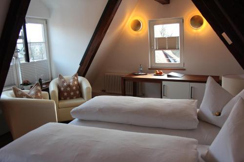 a bedroom with two beds and a desk and a window at Hotel Schmales Haus in Ulm