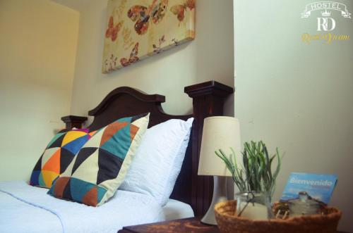 a bedroom with a bed and a table with a lamp at Real Dream Hostel in San Gil
