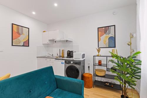 a living room with a blue couch and a kitchen at T2 cosy - stationnement gratuit in Bourg-en-Bresse