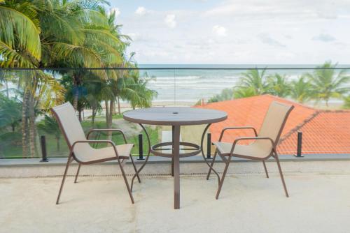 a table and chairs with a view of the ocean at Casa Pé na Areia a 10m da Praia! Imperdível! in Olivença