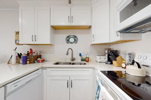 a white kitchen with white cabinets and a sink at Grand Caribbean East & West W305 in Perdido Key