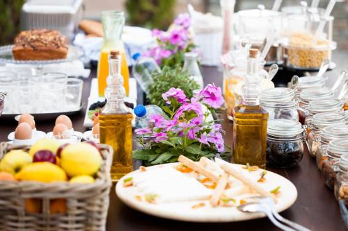 a table with food and flowers and bottles of honey at Ayia Marina Suites in Ouranoupoli