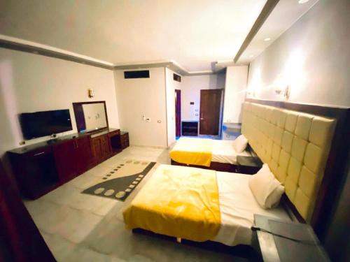 a hotel room with two beds and a flat screen tv at paradise bay hotel in Dahab