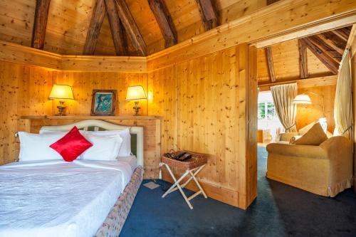 a bedroom with a bed and a couch and a chair at Villa Orso Grigio in Ronzone