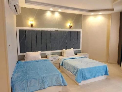 two beds in a room with blue sheets at paradise bay hotel in Dahab