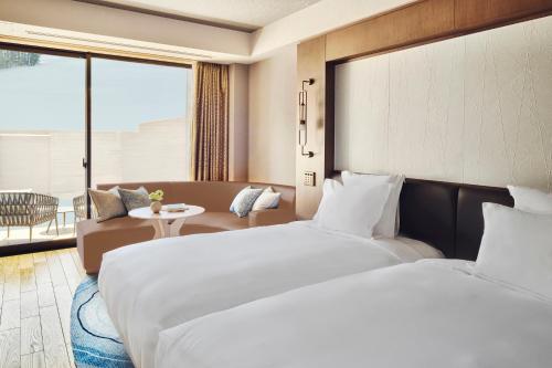 a hotel room with two beds and a couch at ANA InterContinental Appi Kogen Resort by IHG in Hachimantai