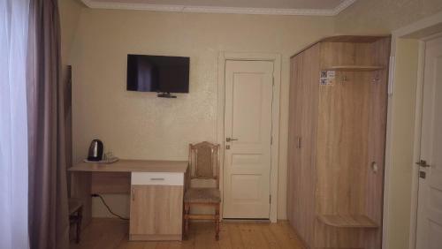 a room with a desk and a television on the wall at Садиба Святослав in Skhidnitsa