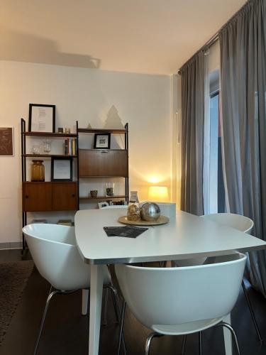 a dining room with a white table and chairs at Civico6 in Tirano