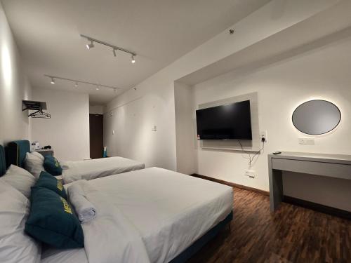 a hotel room with two beds and a flat screen tv at K Avenue Kota Kinabalu by Merveille - Sabah in Donggongon