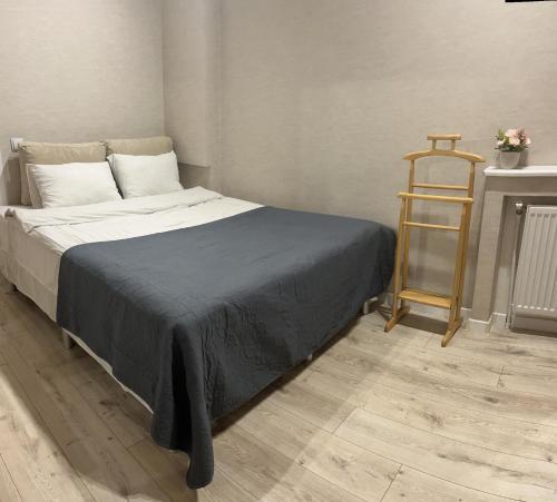 ein Schlafzimmer mit einem Bett und einem Holzregal in der Unterkunft Квартира в центральній частині Луцька in Luzk