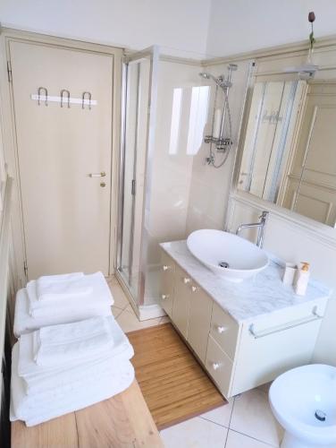 a white bathroom with a sink and a toilet at VM Ravenna Luxury Apartment in Ravenna