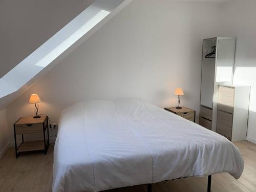 - une chambre avec un lit blanc et 2 tables de chevet dans l'établissement Maison neuve avec jardin, terrasse à PERROS-GUIREC - Réf 918, à Perros-Guirec