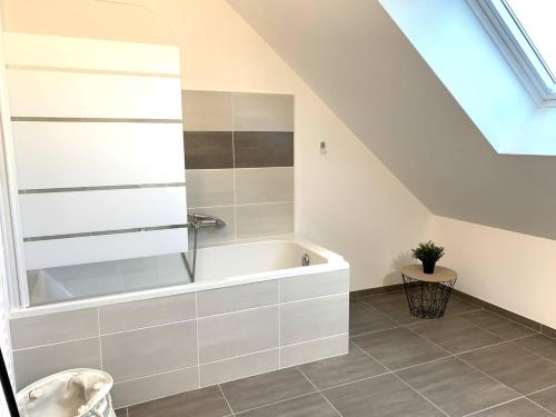 La salle de bains mansardée est pourvue d'une baignoire. dans l'établissement Maison neuve avec jardin, terrasse à PERROS-GUIREC - Réf 918, à Perros-Guirec