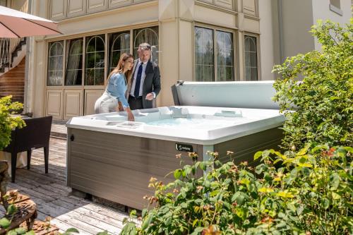 a man and woman standing next to a hot tub at Villa Orso Grigio in Ronzone