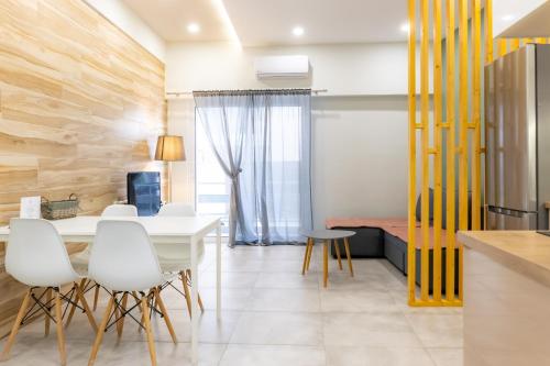 a dining room with a white table and white chairs at P&K LUXURY APARTMENTS 1 in Kalamata