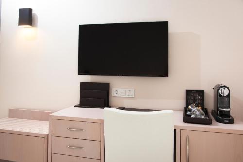 a room with a flat screen tv on a wall at Ayia Marina Suites in Ouranoupoli