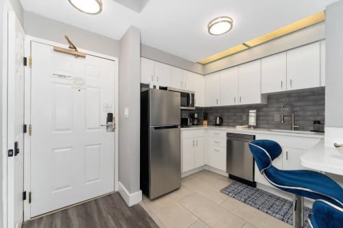 a kitchen with a refrigerator and a blue chair at Orlando Comfort Close to Top Attractions in Orlando