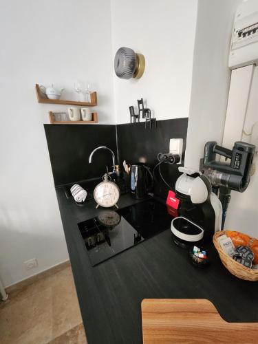 a kitchen with a black counter with a coffee maker at Le Studio des Fontêtes Climatisé in Aix-en-Provence