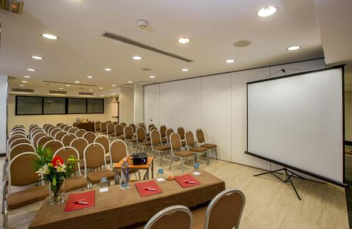 a conference room with chairs and a white screen at Leonardo Hotel Madrid City Center in Madrid