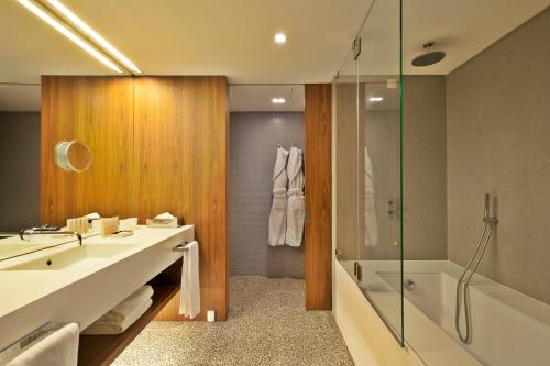a bathroom with a sink and a shower and a tub at Altis Prime Hotel in Lisbon