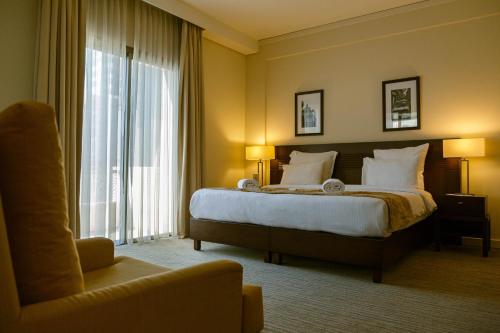 una habitación de hotel con una cama y una silla en The Parisian Hotel, en Beirut