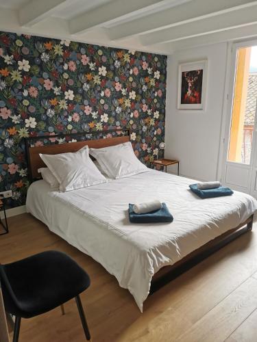 - une chambre avec un grand lit et un mur fleuri dans l'établissement T3 terrasse classé 4 étoiles le Poulpe 200m front de mer, à Banyuls-sur-Mer