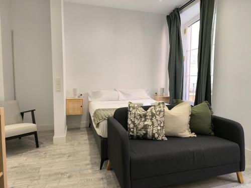 a living room with a couch and a bed at INSIDEHOME Ciudad del Cine a 3 minutos de la Plaza Mayor in Valladolid