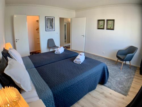 a bedroom with a blue bed with two towels on it at Kaupunkikoti 3-room apartments D53 in Kemi
