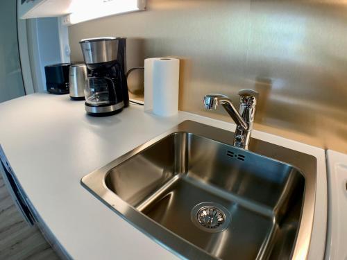 a kitchen counter with a sink and a coffee maker at Kaupunkikoti 3-room apartments D53 in Kemi