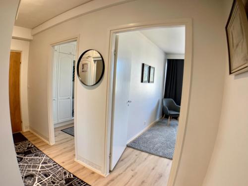a hallway with a mirror and a chair at Kaupunkikoti 3-room apartments D53 in Kemi