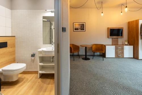 a bathroom with a toilet and a sink and a table at Dwór Kolesin in Nowe Kramsko
